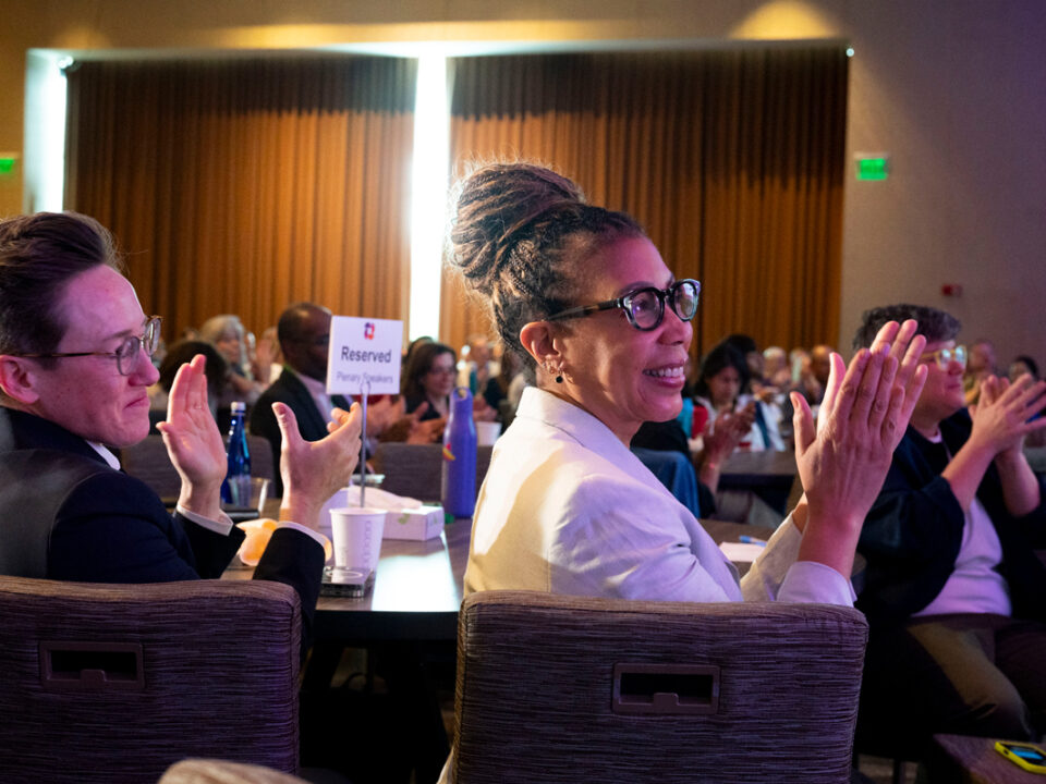 Attendees applaud during a plenary session at a GEO conference.
