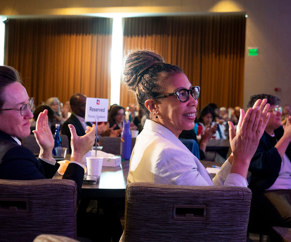 Attendees applaud during a plenary session at a GEO conference.